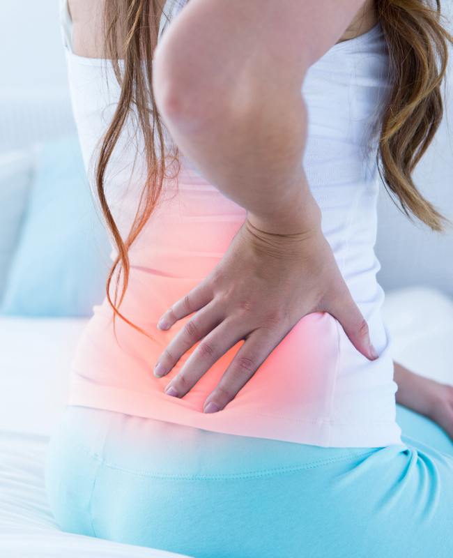 The image of a woman holding her lower hand with low back pain.