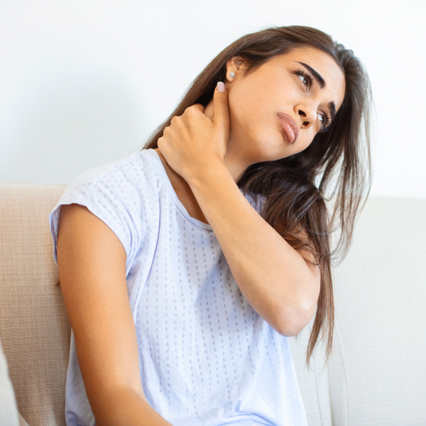 A woman rubbing her neck due to neck pain.